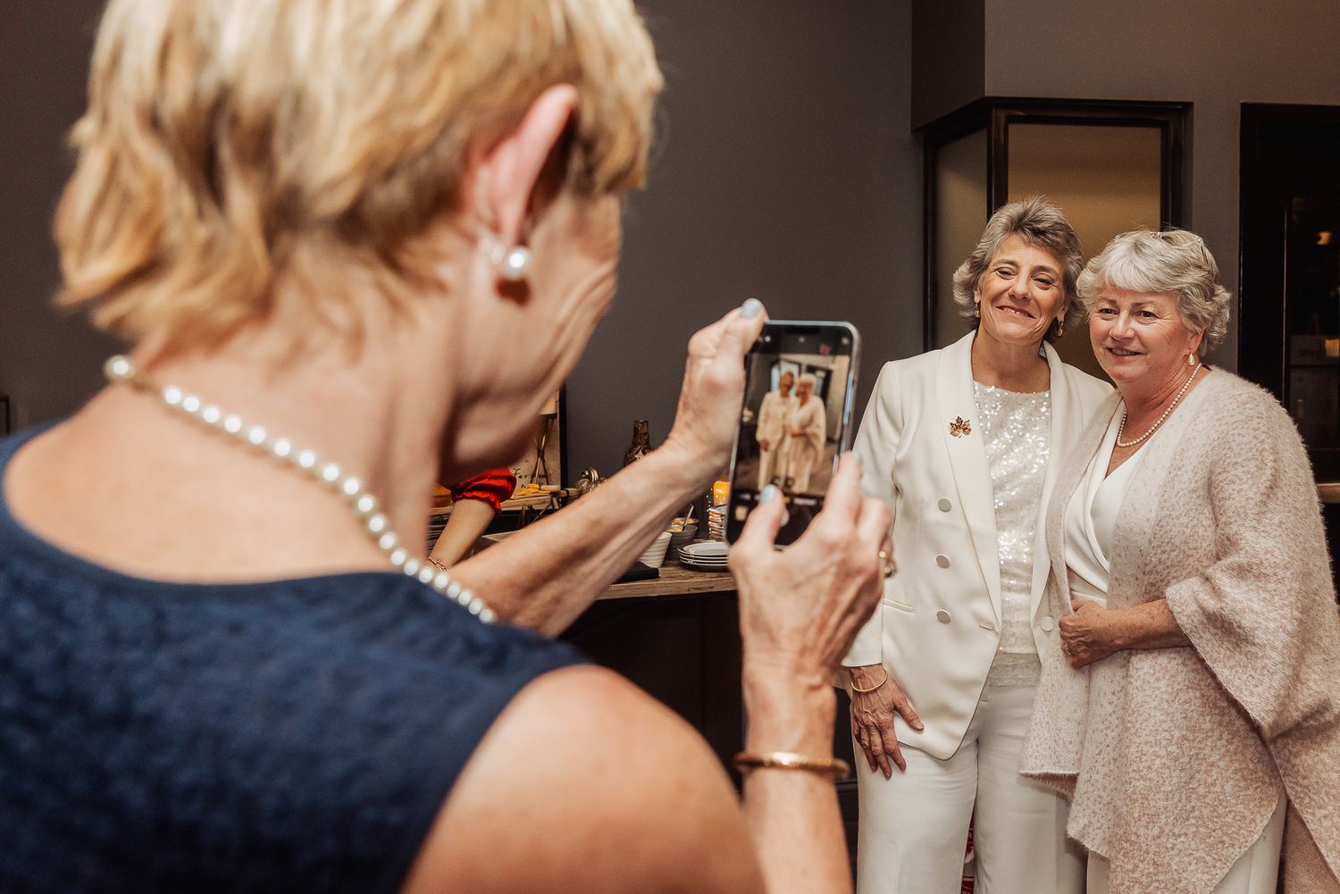 Someone taking a photo of two people posing together at a formal event.