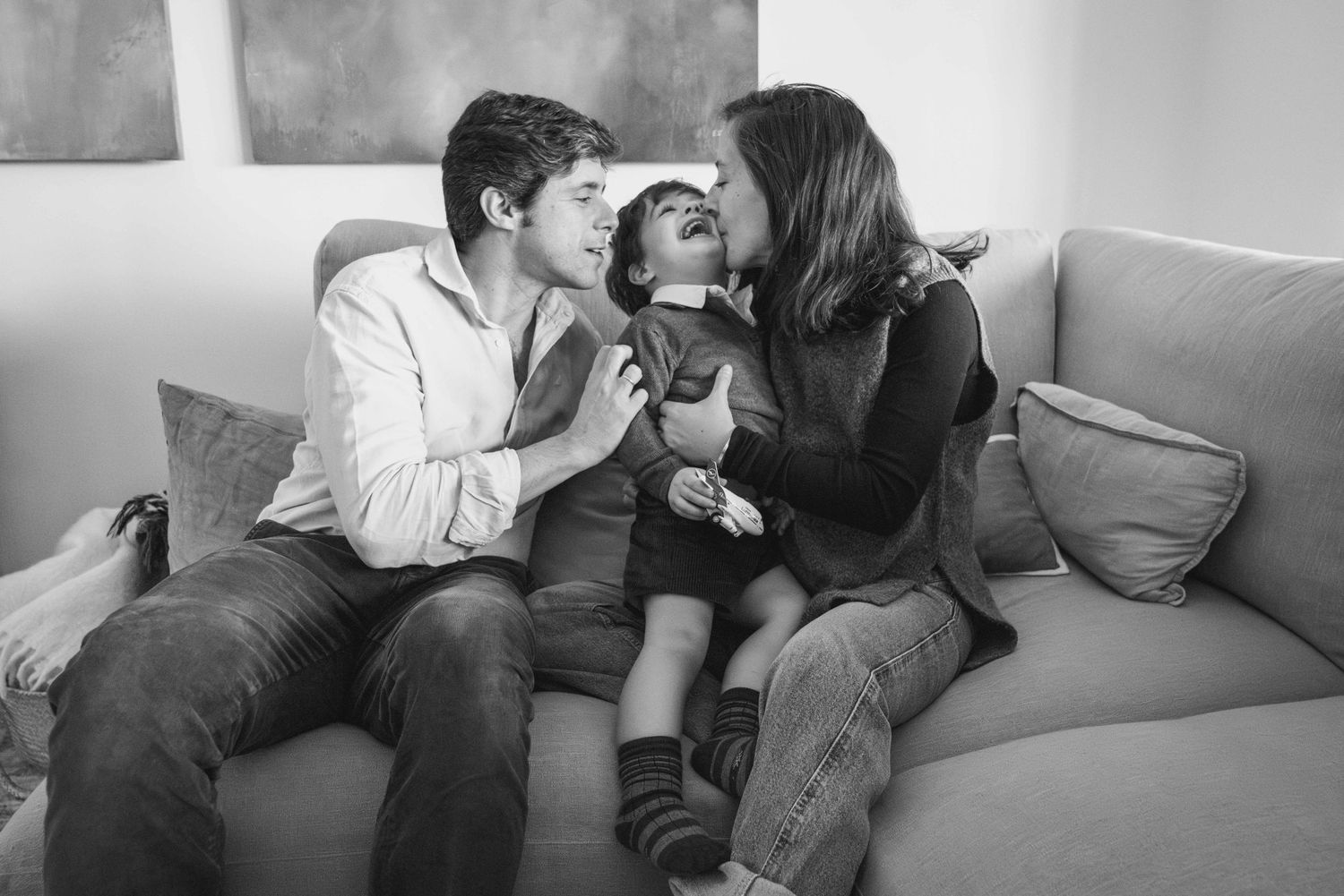 sesión de fotos familiar con niños. dos padres dando un beso a su hijo