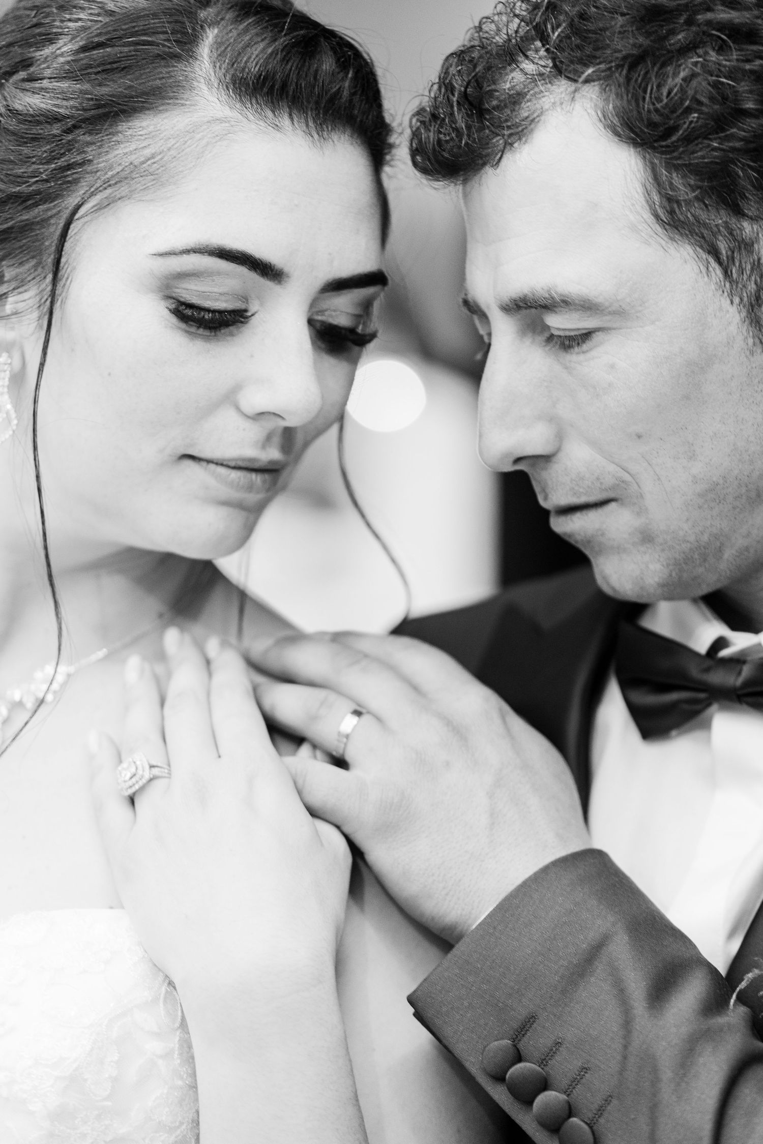 Intimate black and white portrait of newlyweds in formal wedding attire.