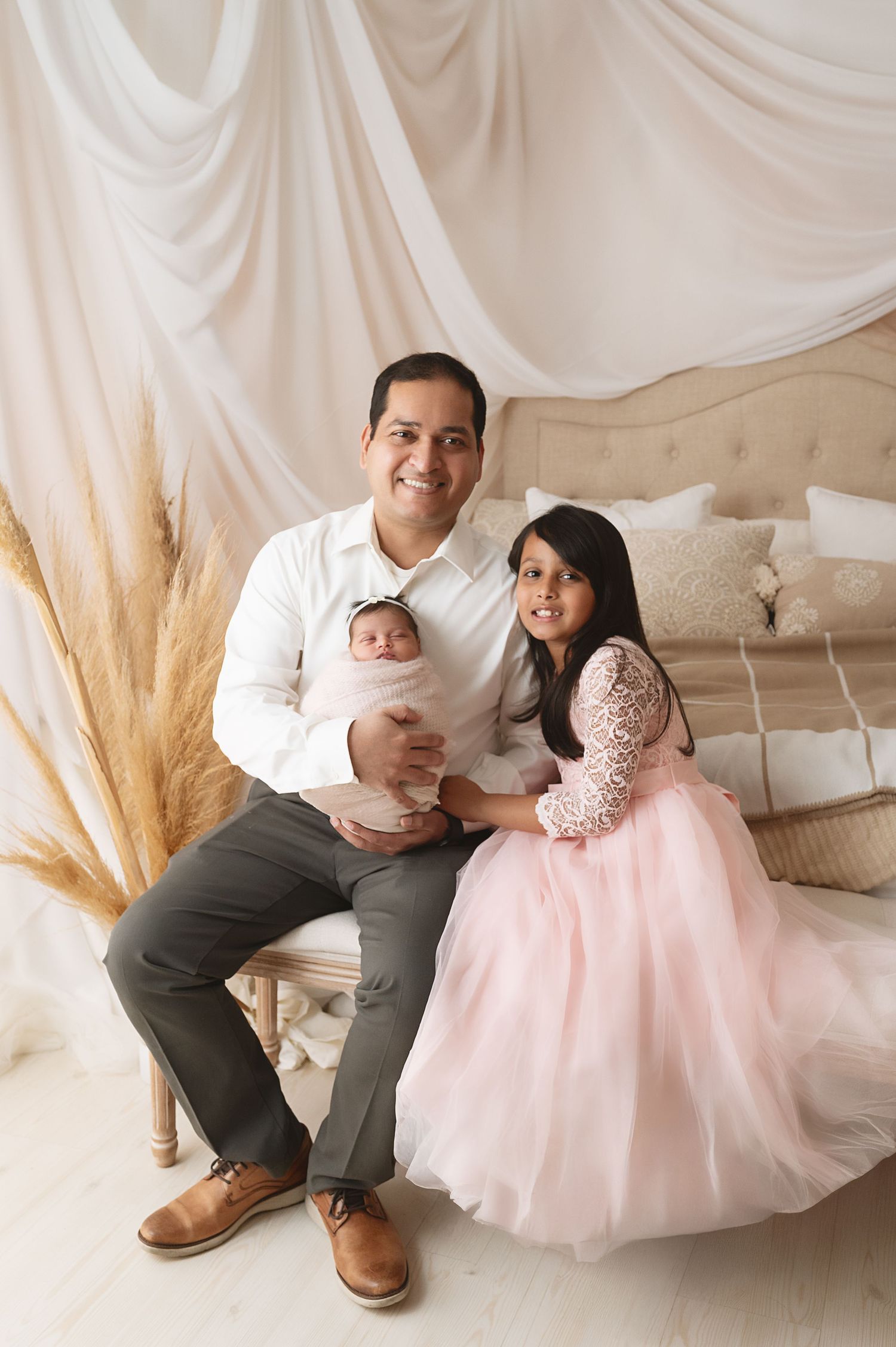 Family photo session with neutral tones and white draping backdrop.