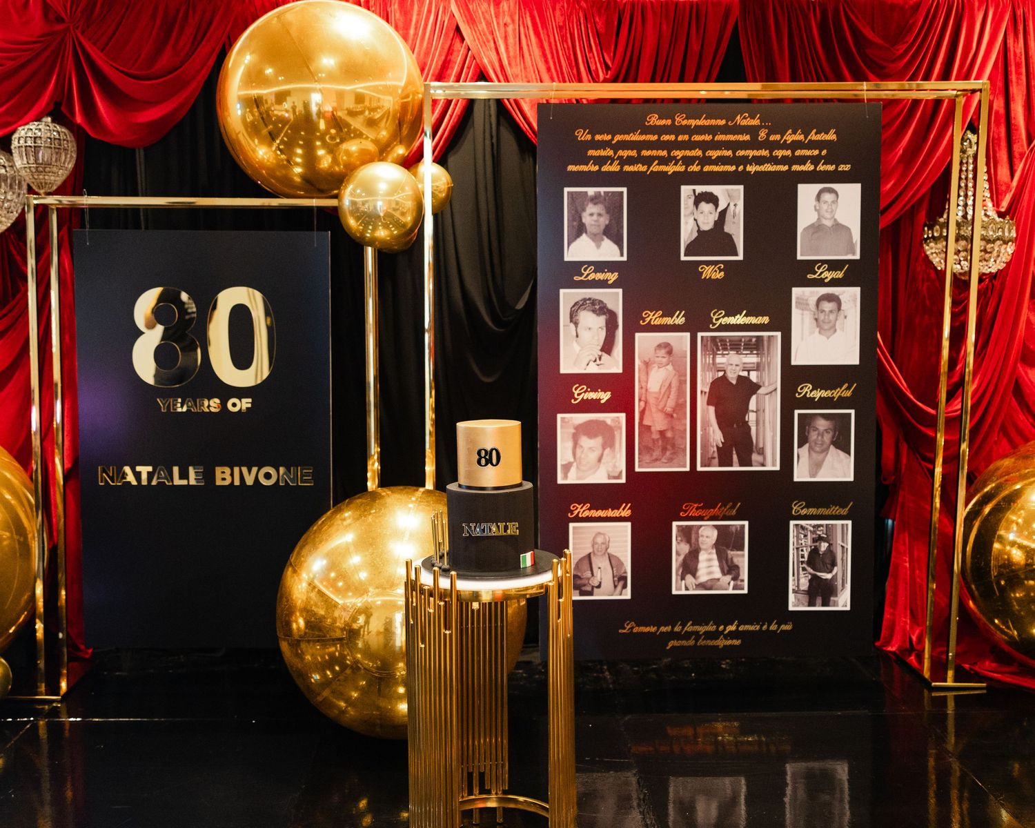 Black and gold display with large decorative balloons, curtains, and photo frames creates an elegant event backdrop setup.