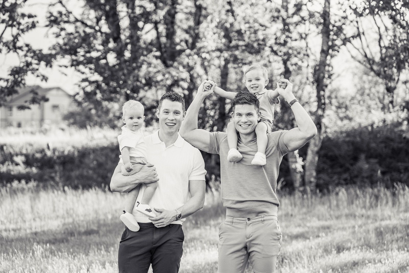 Black and white photo of two dads with their sons.
