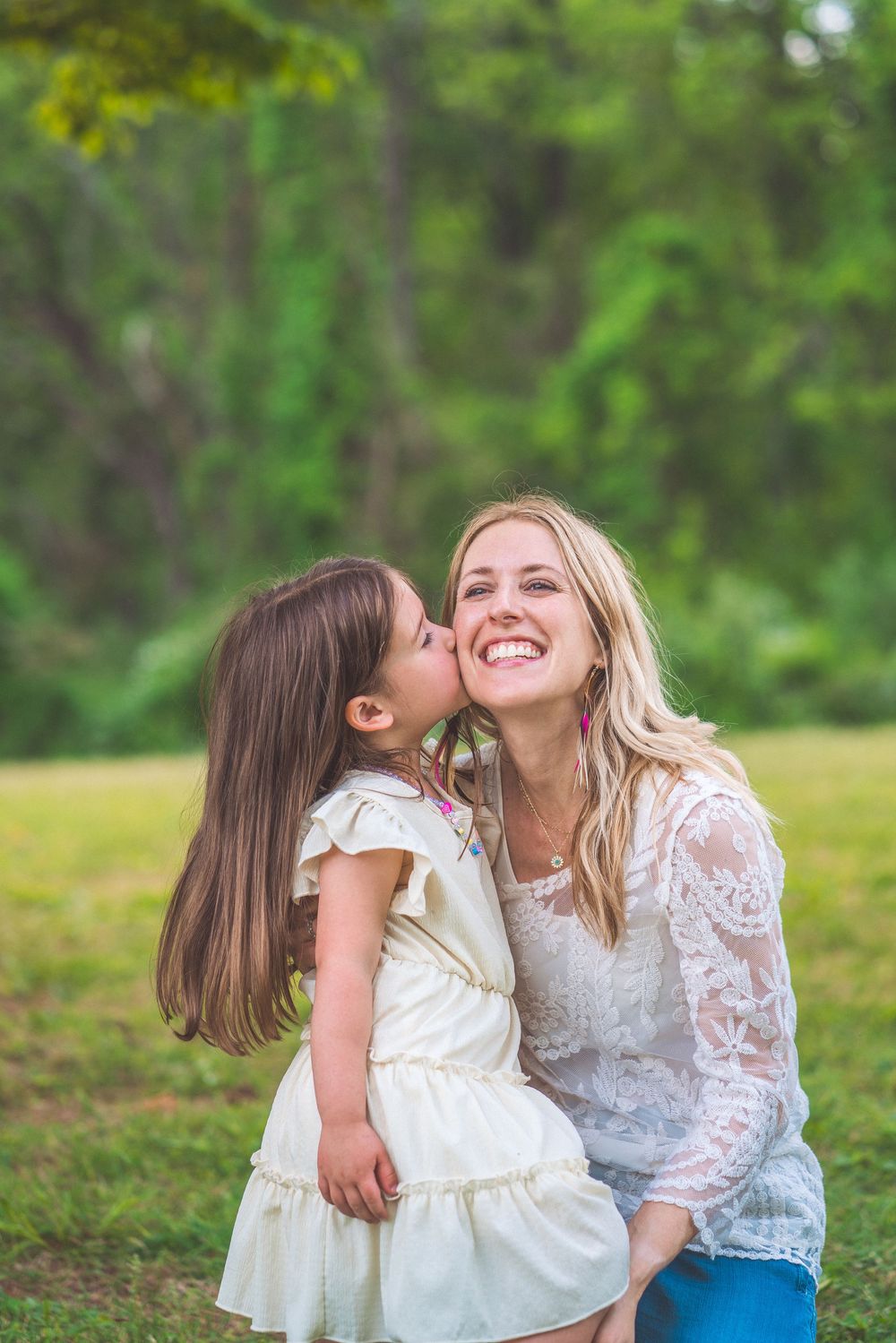 Sweet moment of affection shared between parent and child in outdoor garden setting.