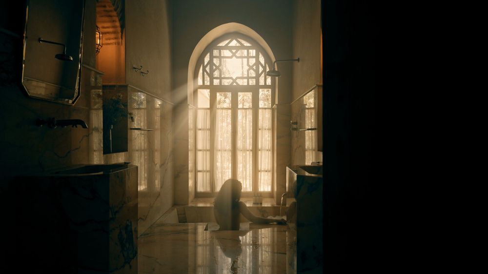 Interior panorama of a gothic cathedral with sunlight streaming through stained glass windows creating dramatic lighting.