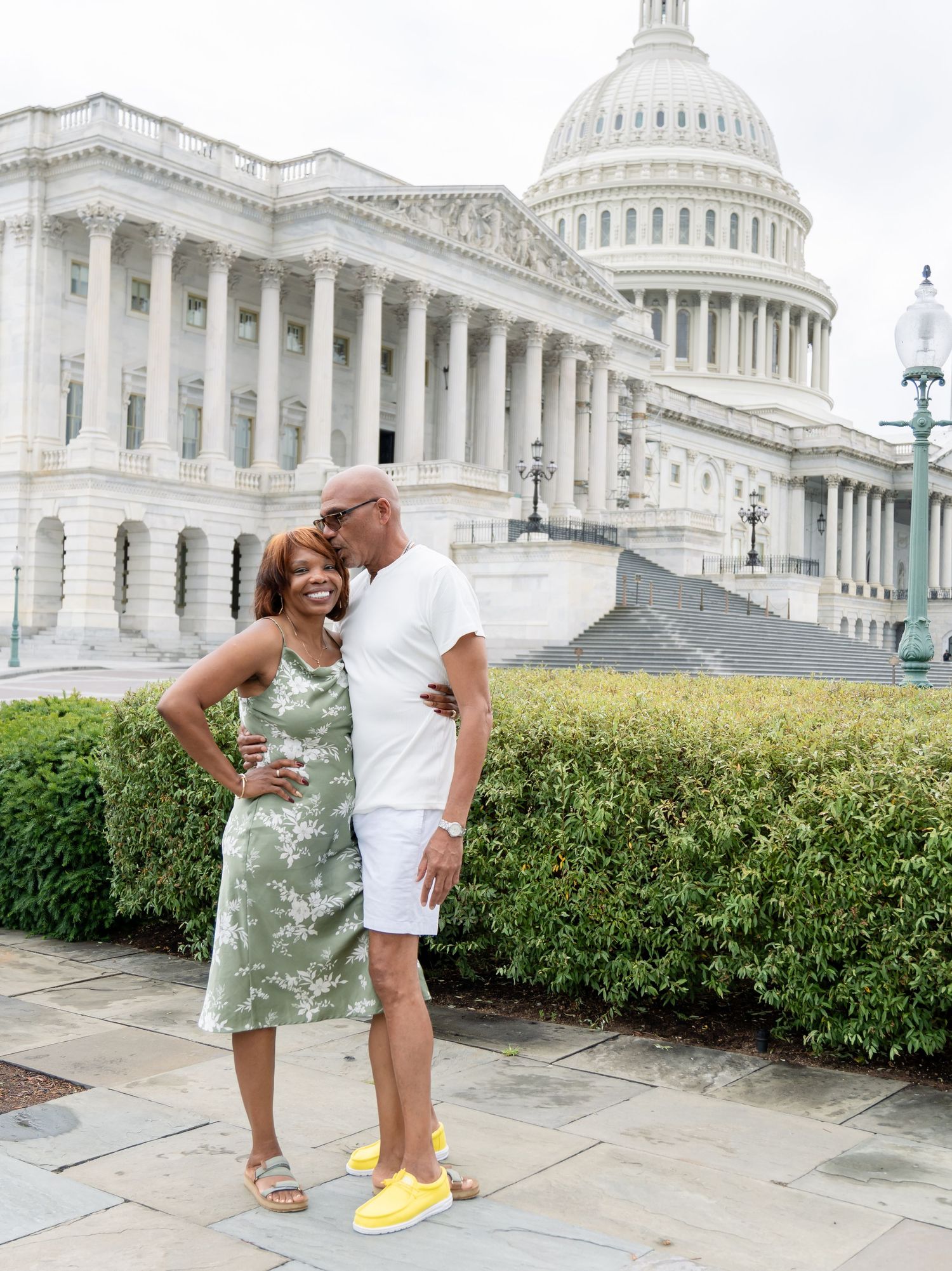 A couple poses together on a sunny day in front of the United States Capitol building in Washington DC.