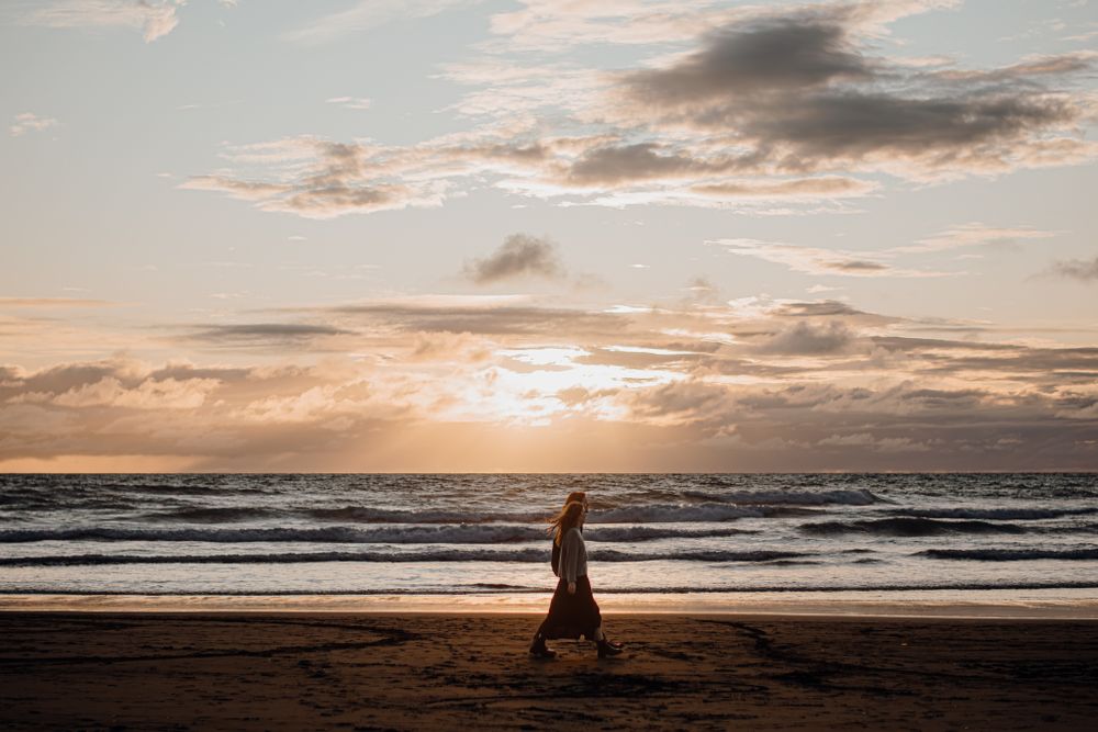 A walking couple for their engagement shoot in Piha with Apertured Media-Auckland Wedding and Elopement Photographer