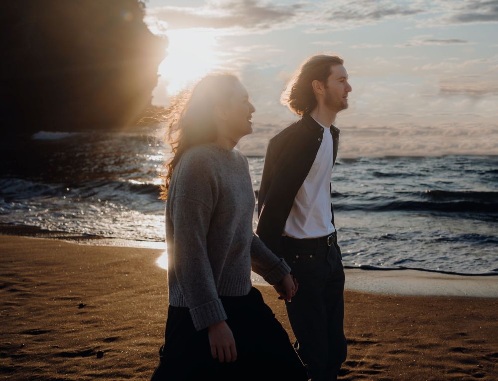 A couple and sunset for their engagement shoot in Piha with Apertured Media-Auckland Wedding and Elopement Photographer