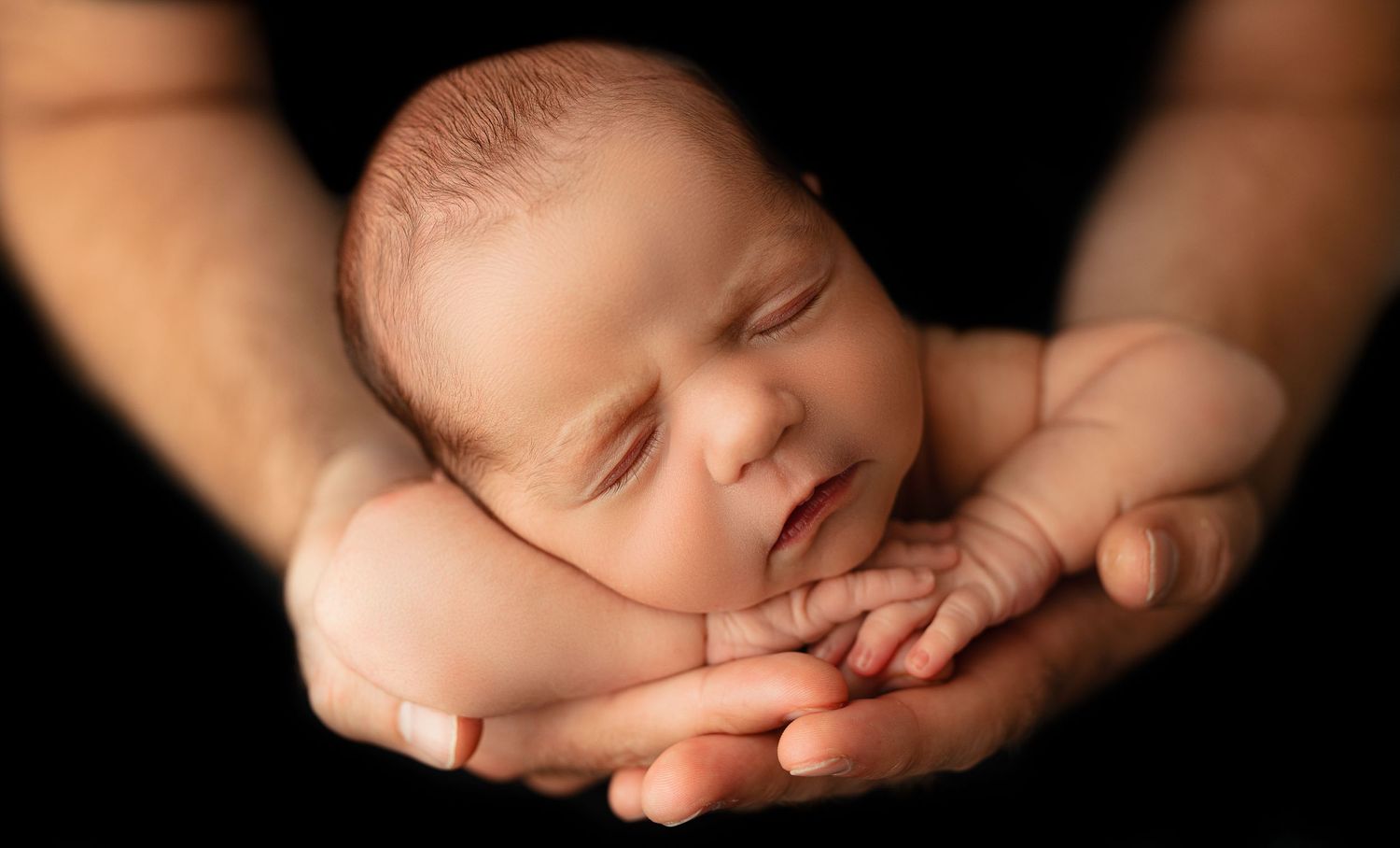 baby posed in hands indianapolis