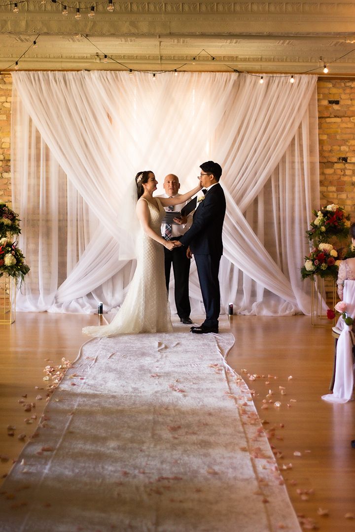 couple and officiant at the front of the altar