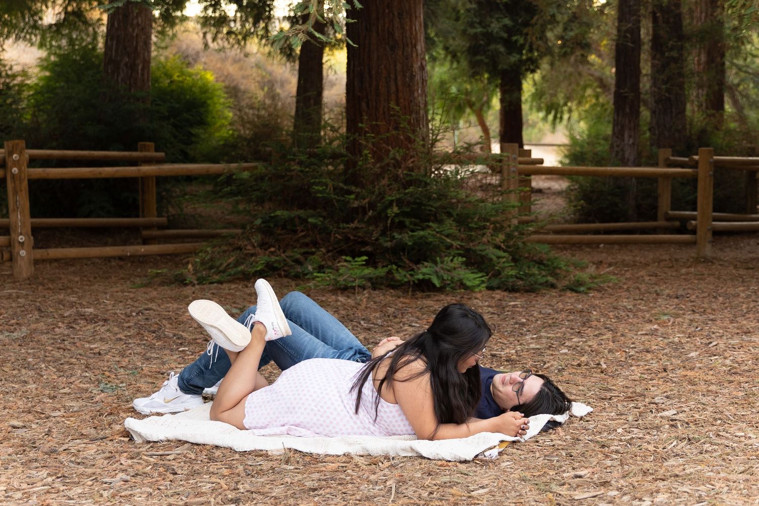 couple laying on a blanket by the mini redwoods
