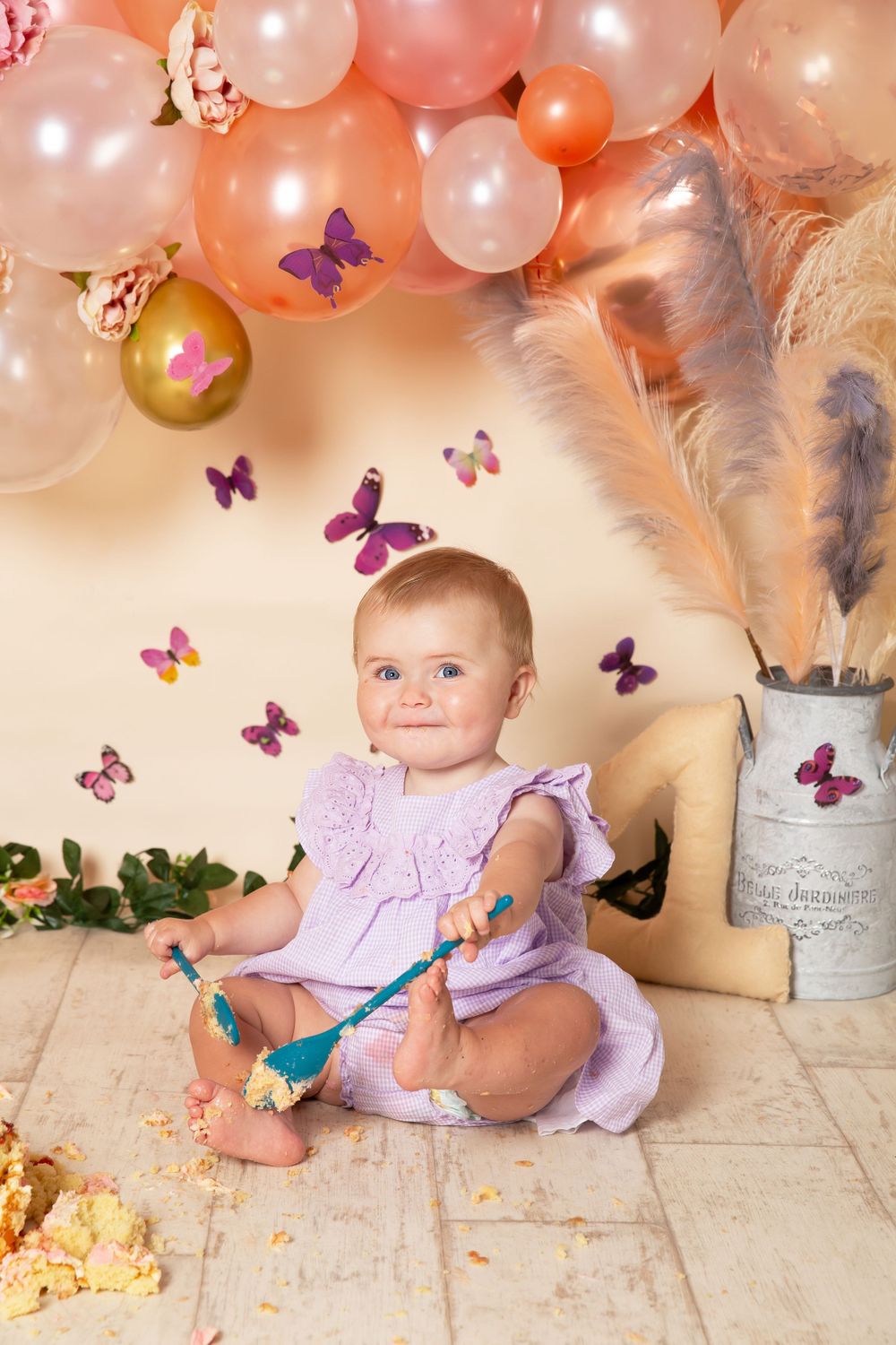 cake smash background coral balloons and butterflied and child holding spoons