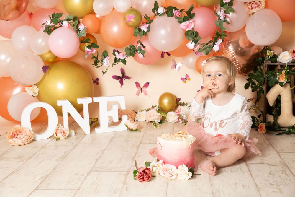 coral balloon and flower background and a child eating cake