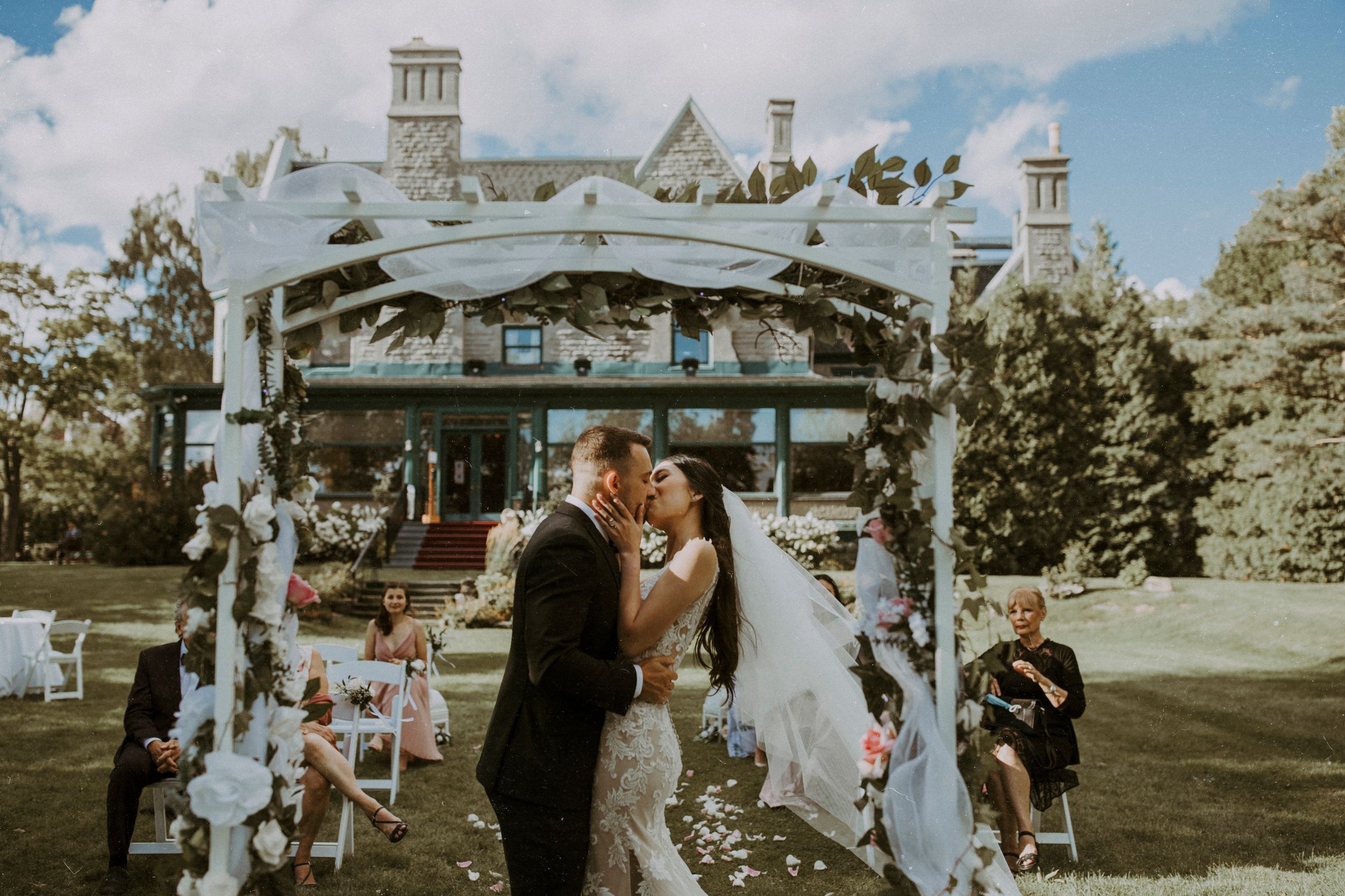 bride and grrom first kiss during their micro wedding ceremony at the forest and stream club, montreal, quebec