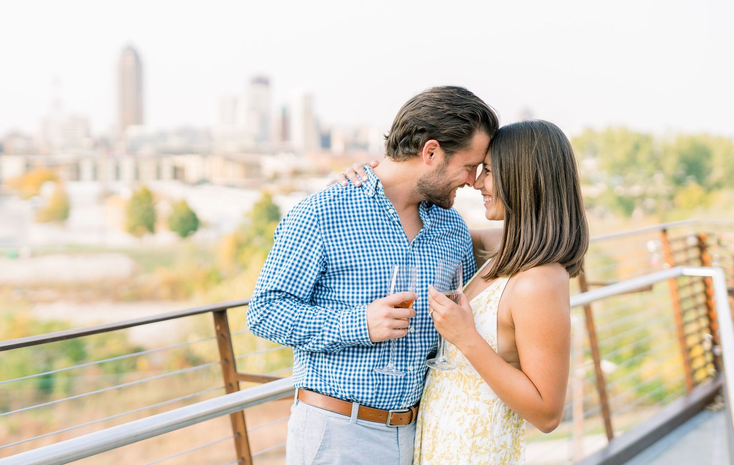 Des Moines Engagement photos with skyline of downtown Des Moines, Iowa with light and airy photographer Nicole Laing