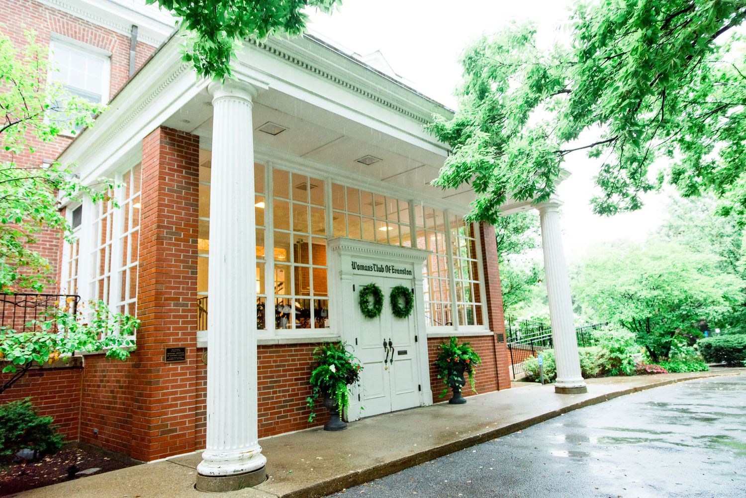 entrance to the Woman's Club of Evanston with wreaths on the door and a wet driveway from the rain