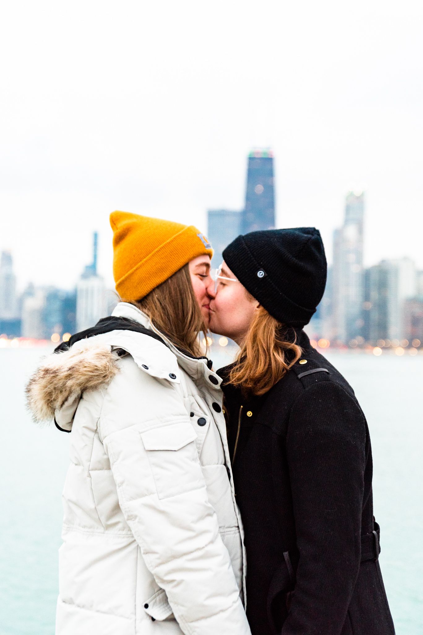two women on pier at North Avenue Beach kissing after proposal in Chicago