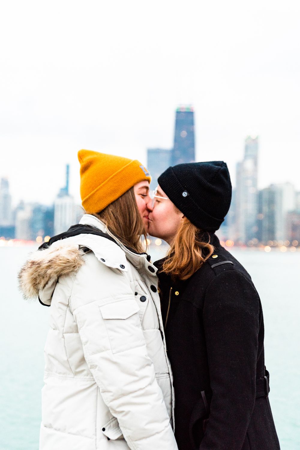 two women on pier at North Avenue Beach kissing after proposal in Chicago