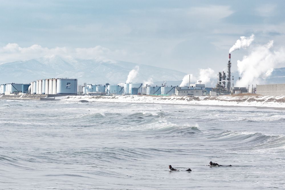 Winter coldwater surfing in industrial Japan with smoke and chimneys pollution