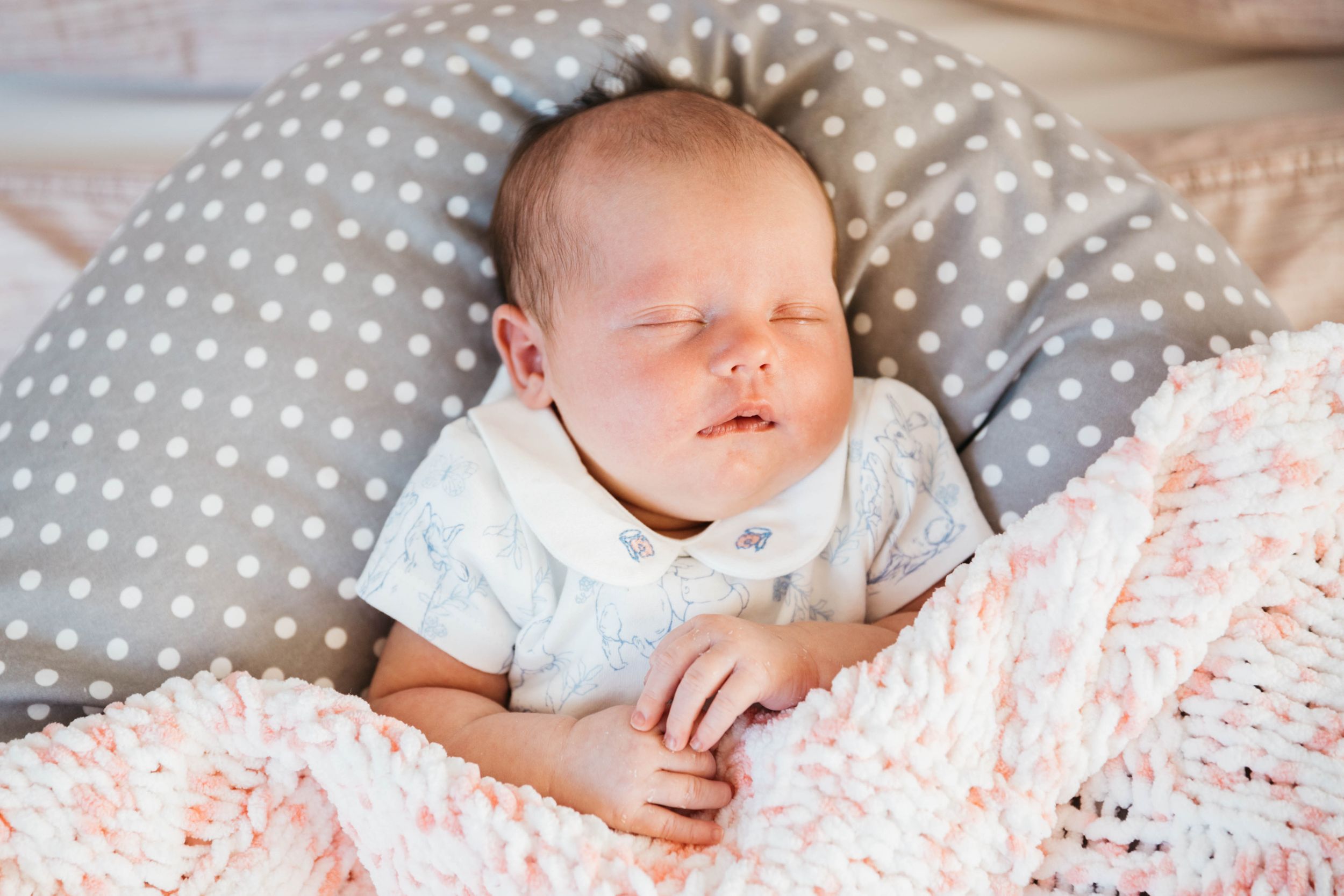12 day old baby girl sleeping in grey bed