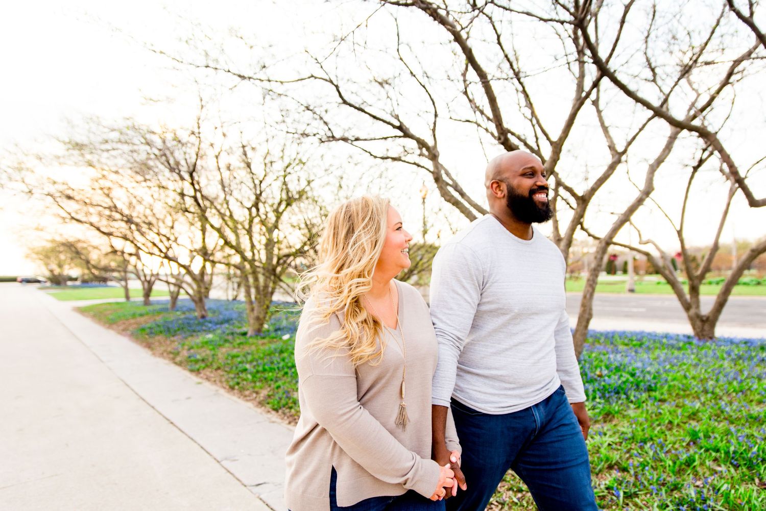 man and woman holding hands laughing in Grant Park sunrise engagement pictures in Chicago