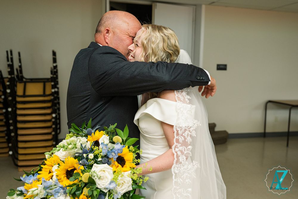 An intimate moment shared with bright sunflower bouquet in foreground.