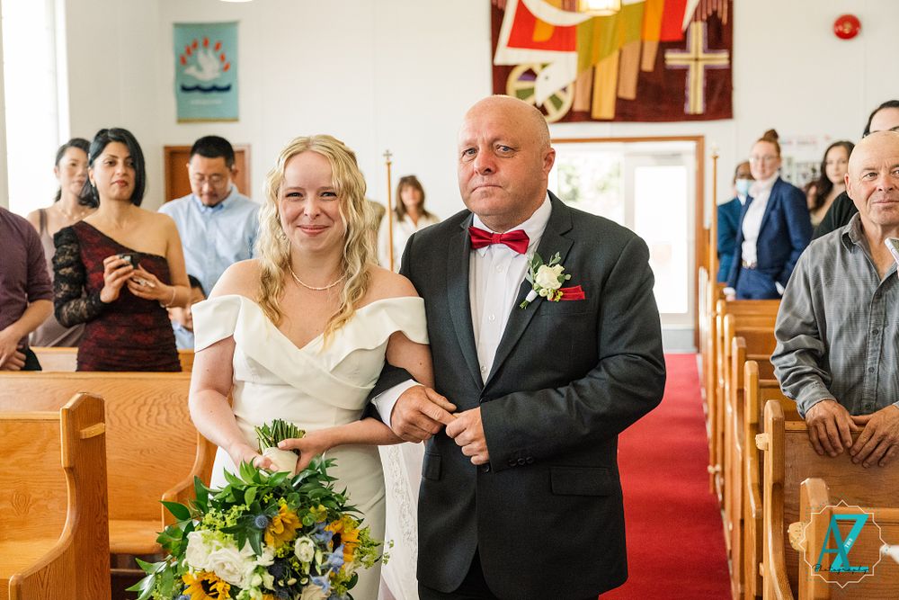 Wedding ceremony in progress with couple walking down red-carpeted church aisle.
