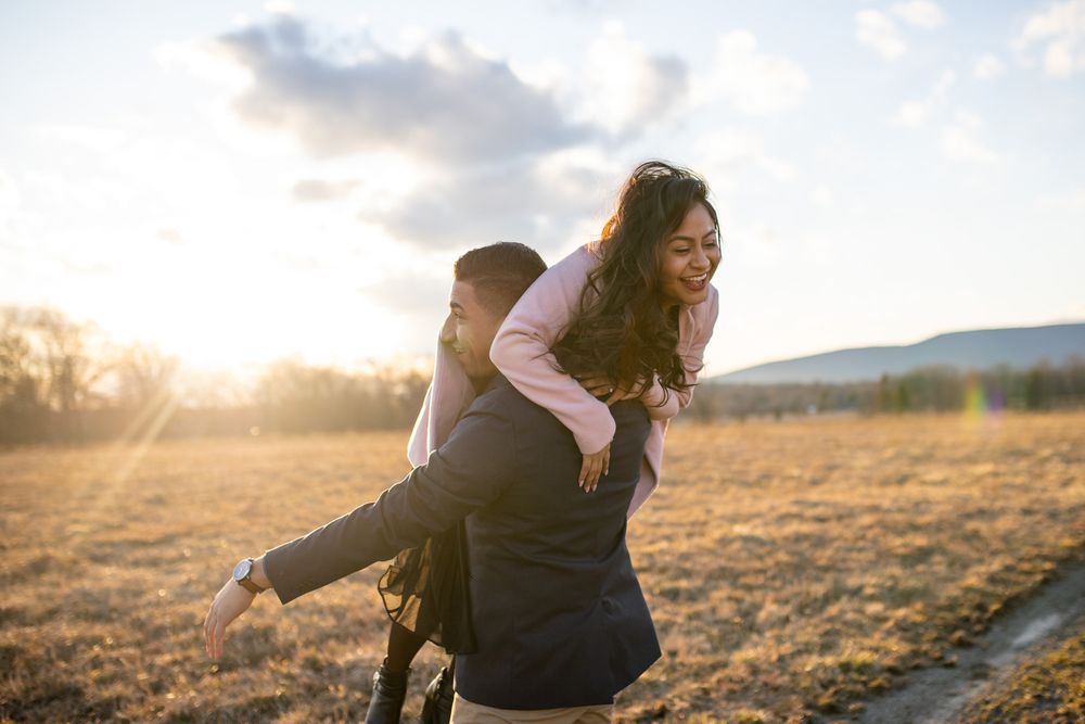 Couple laugh and play during candid adventure engagement session