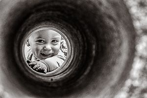 Boy peering through concrete tunnel by Melbourne family photographer Kate Cashin.