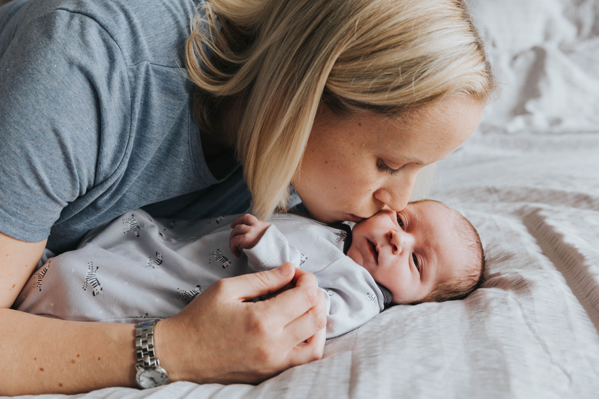 mum kissing new baby boy son