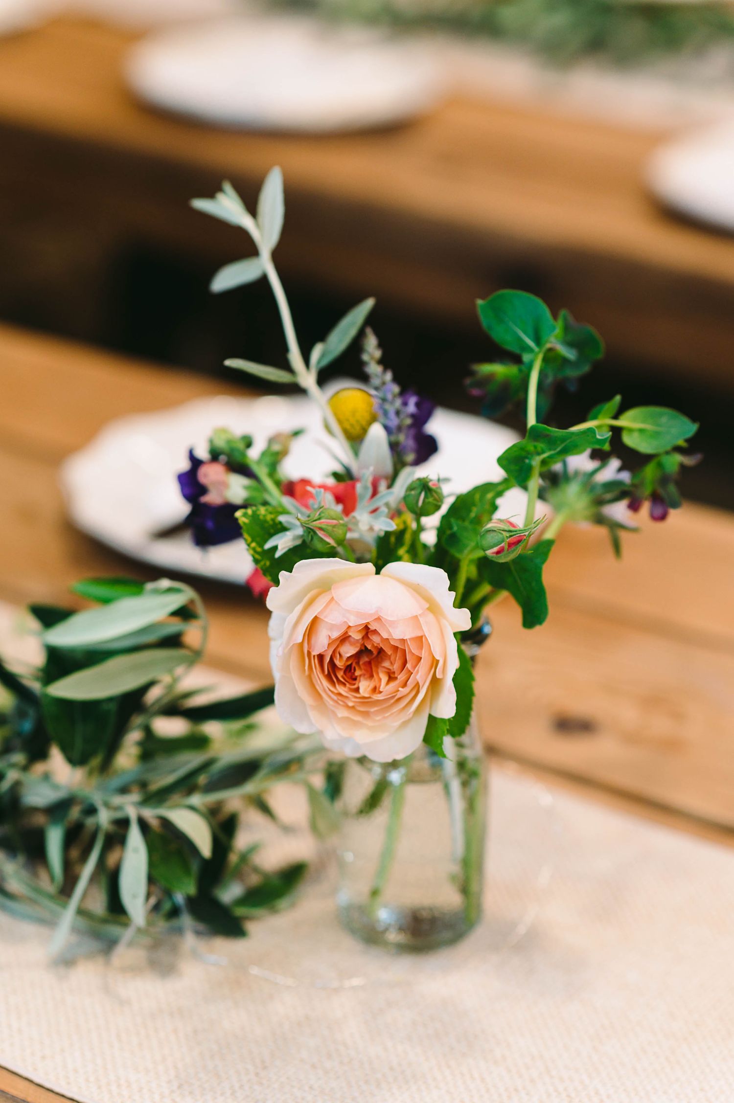 Pastel colored roses on the reception tails inside the barn.
