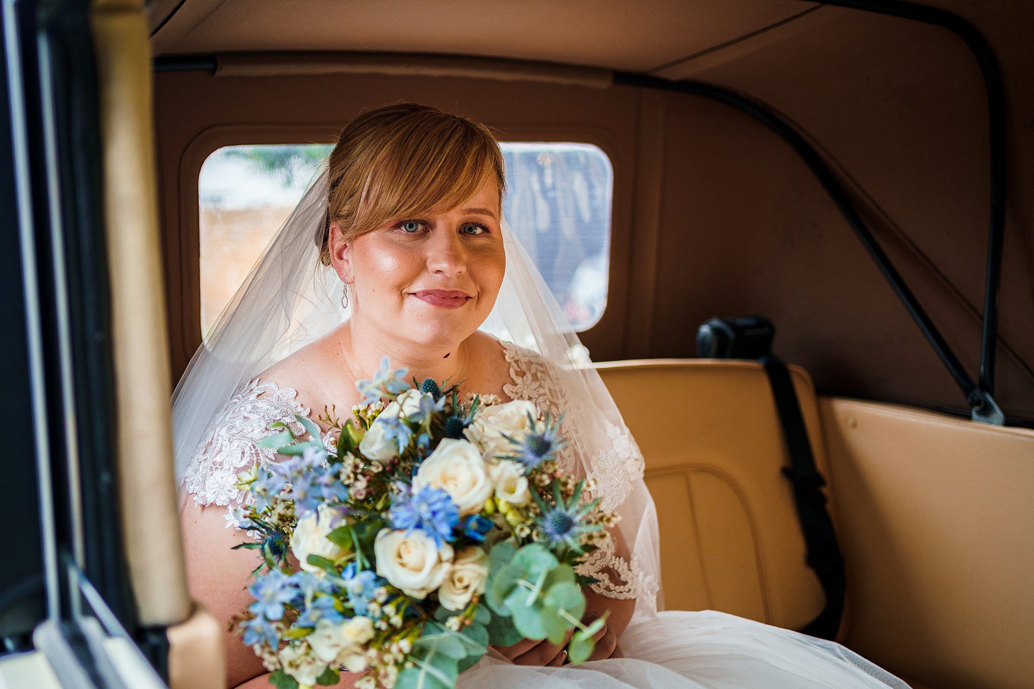 Bride in Northampton wedding car looking at camera