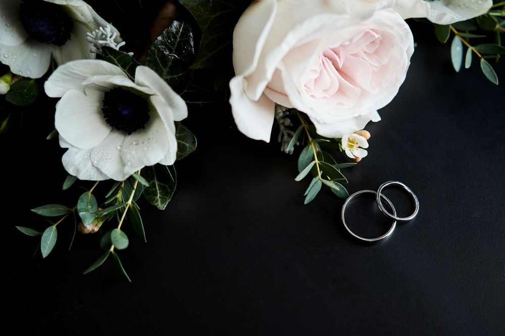 bride and grooms rings with button holes flaylay by Norfolk Wedding Photographer Faye Amare