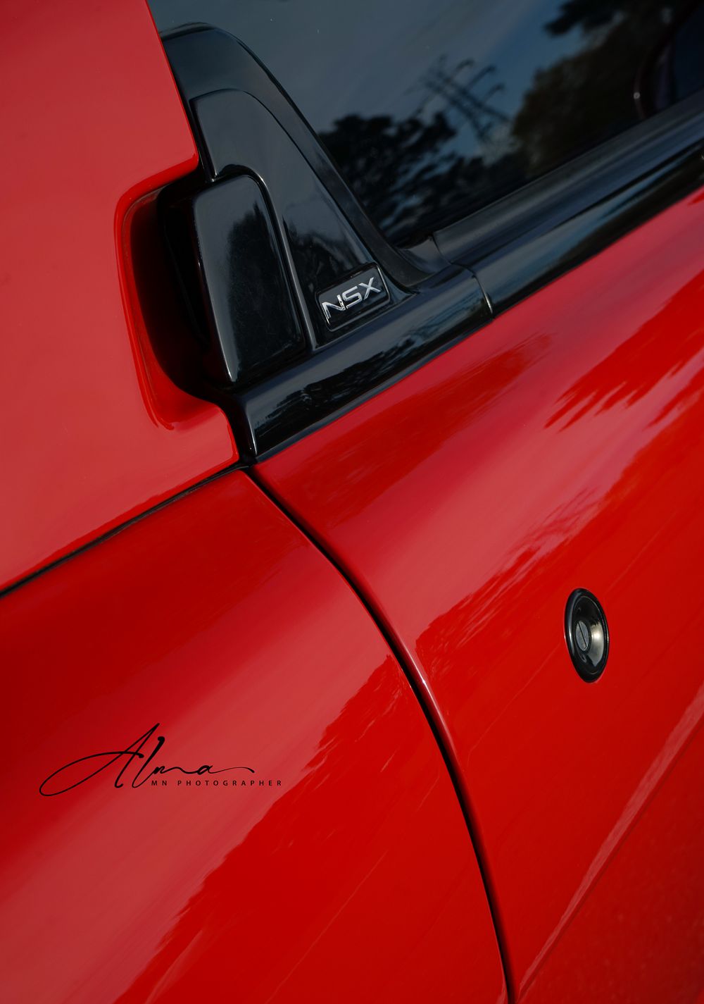 Close-up detail shot of red NSX side mirror and body panel.