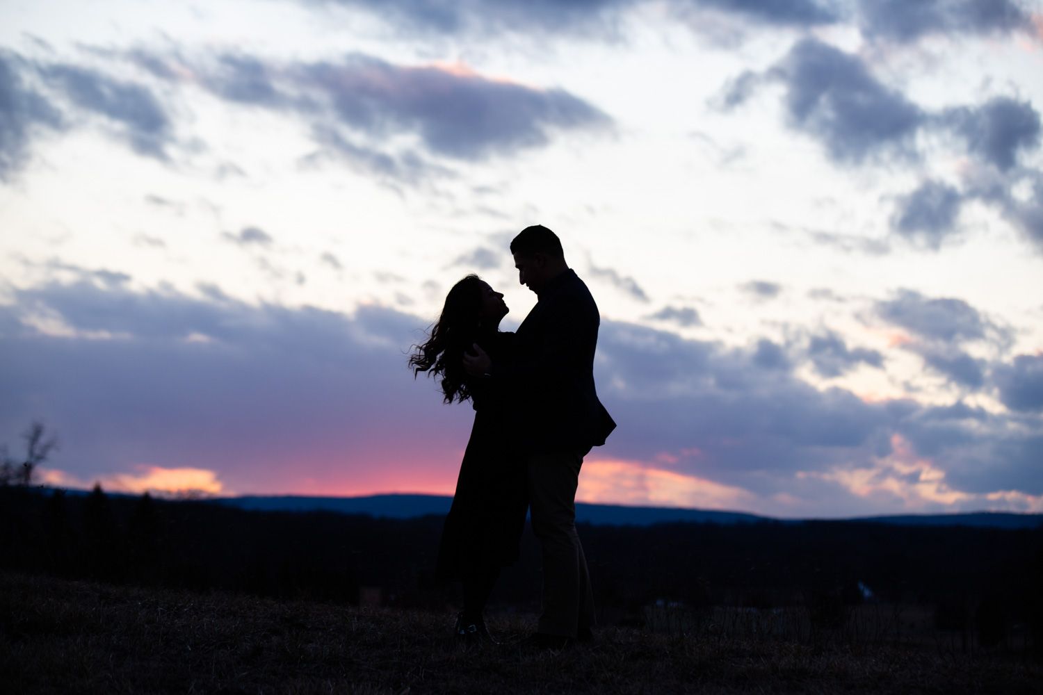 Engaged couple with sunset backdrop