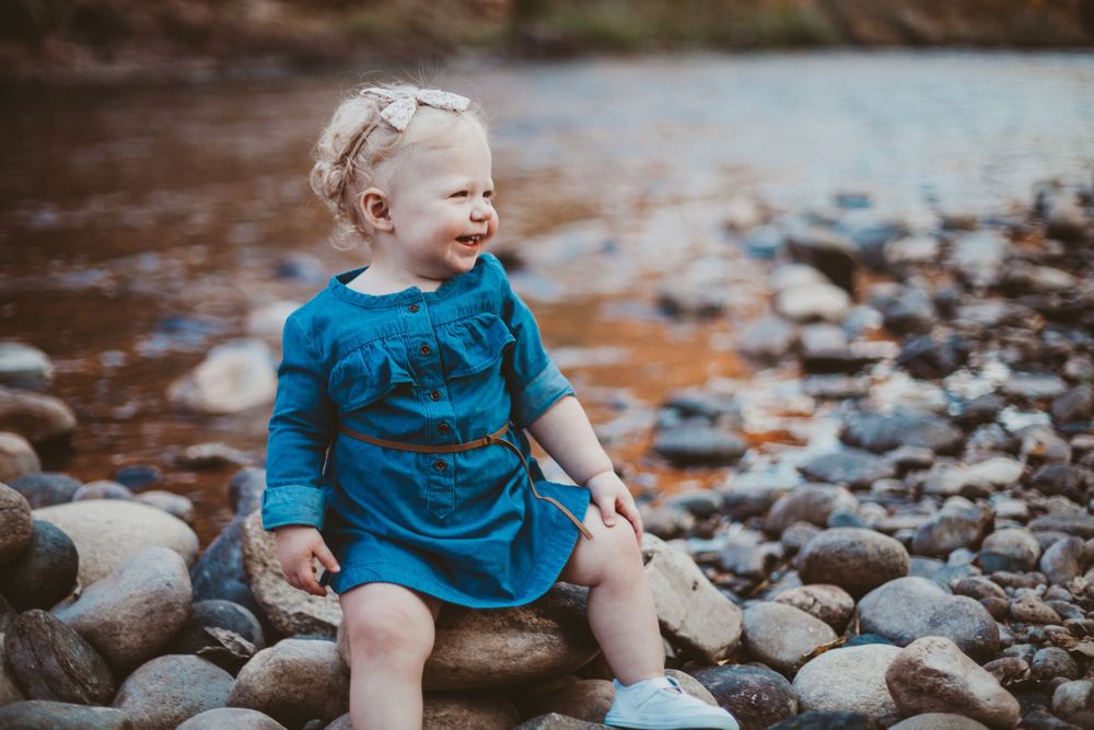 A baby poses for a photo at Watson Lake Natural Area in Fort Collins, Colorado during a Family Photography Session.
