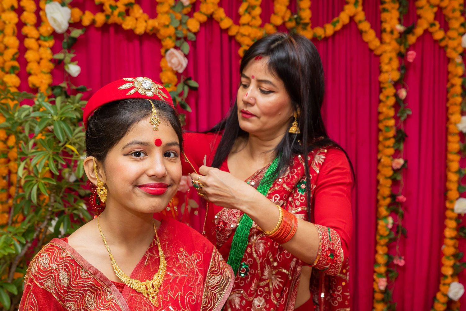 Traditional Hindu ceremony with floral decorations and women in red saris.