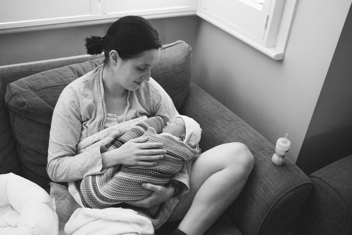 woman holding newly born baby covered in blanket