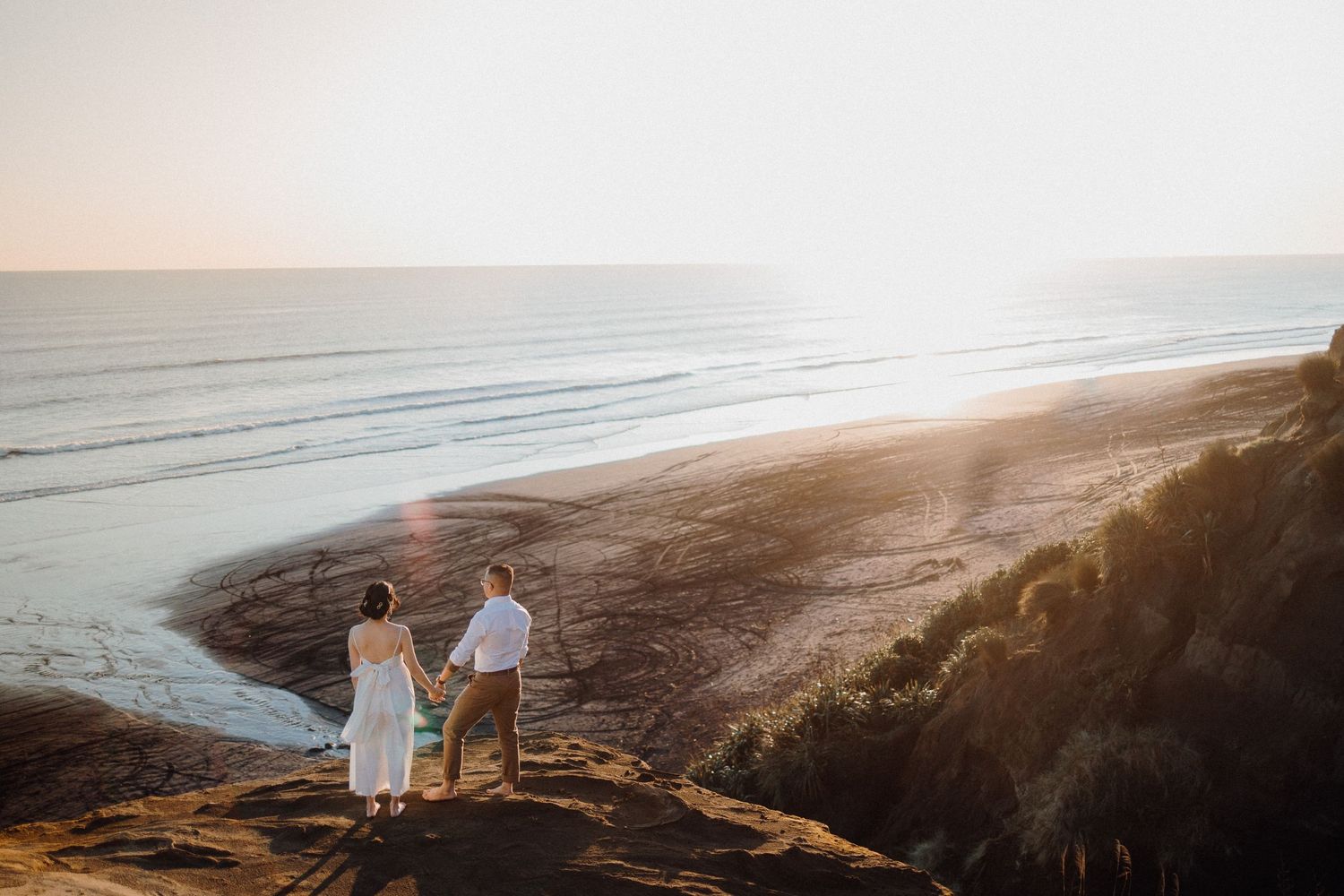 Engaged couple in Karioitahi Beach cliff for their engagement shoot with Apertured Media-Auckland Wedding Photographer