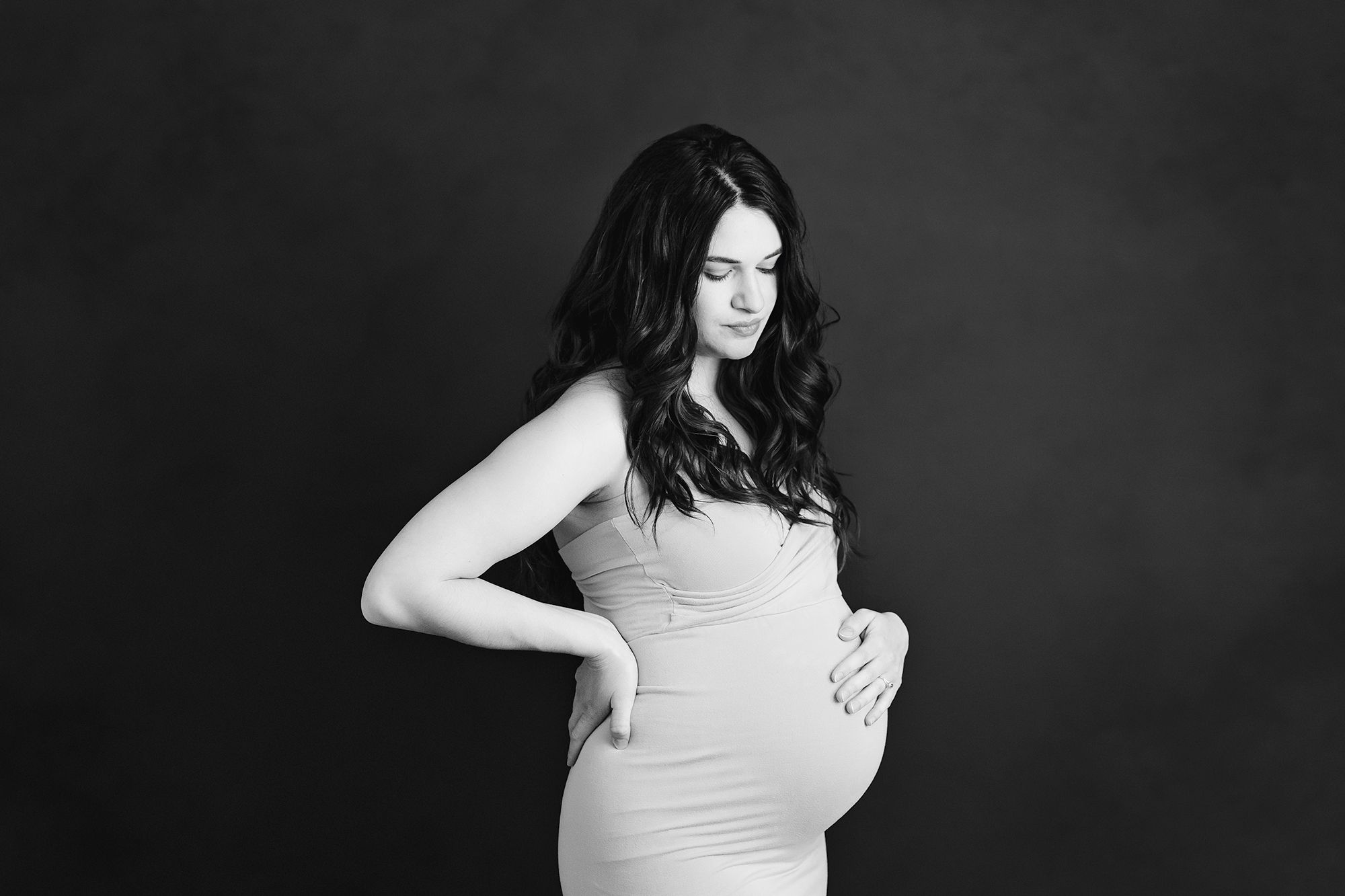 studio maternity photo shoot kansas city pregnant woman holding baby bump