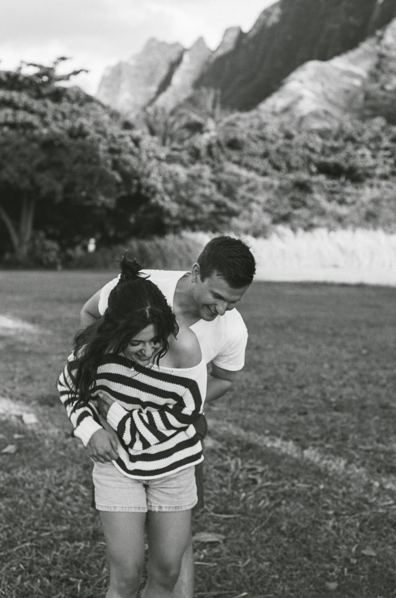 Romantic couple embraces on Hawaiian beach during photoshoot