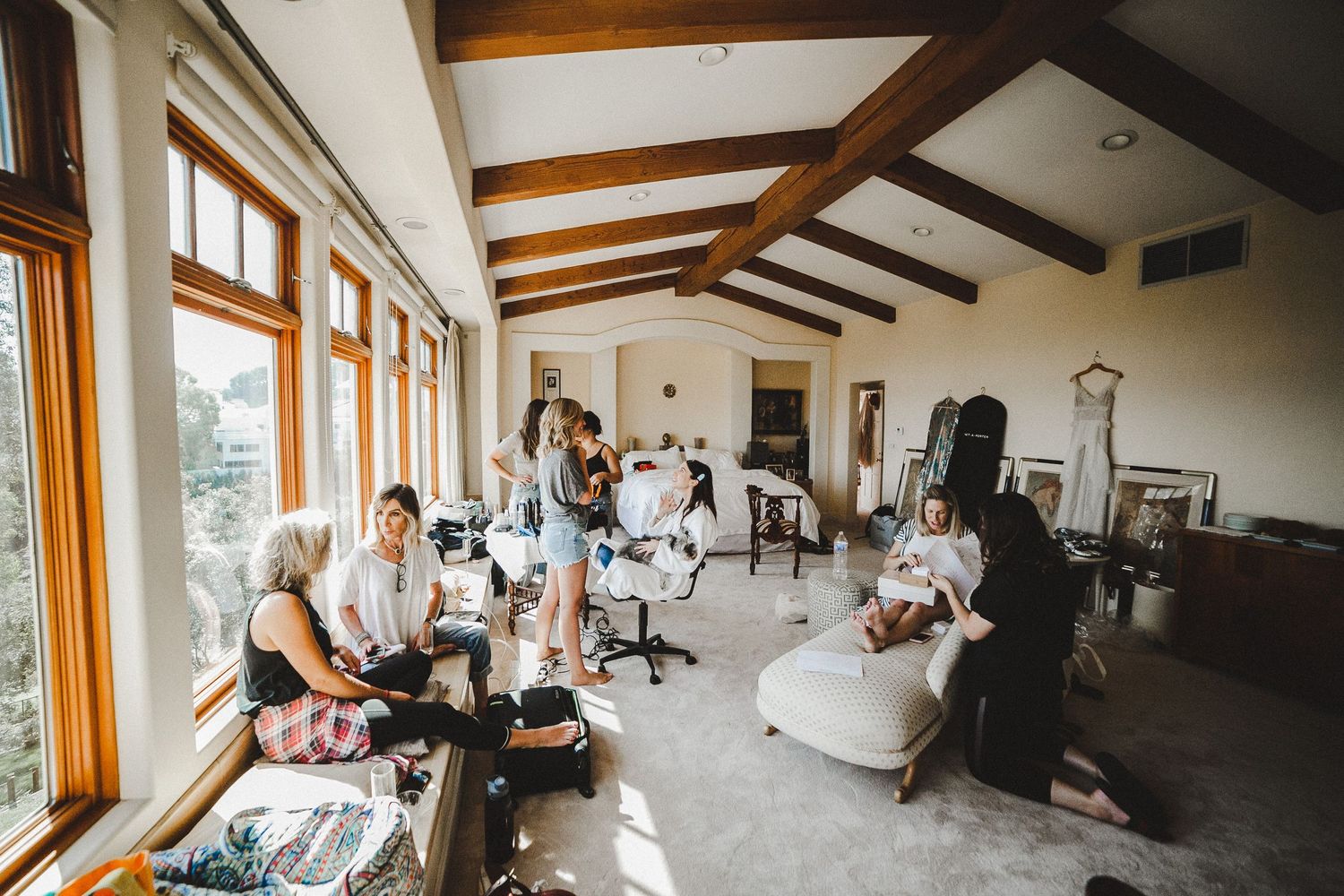wide shot of bride and family getting ready inside master bedroom