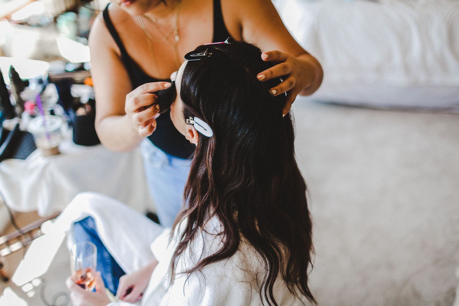makeup artist putting on makeup for bride