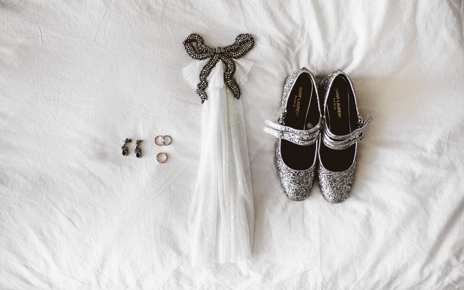 detail shot of dress, garter, rings, shoes of bride