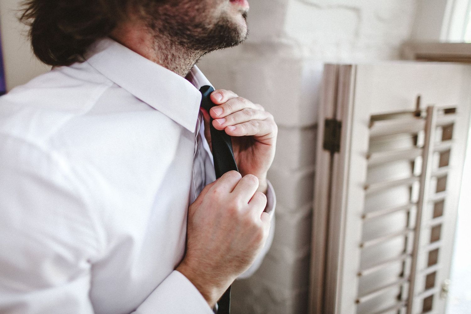 groom adjusting tie
