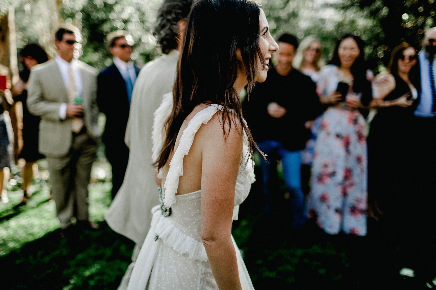 side shot of bride walking down and seeing guests in her wedding dress