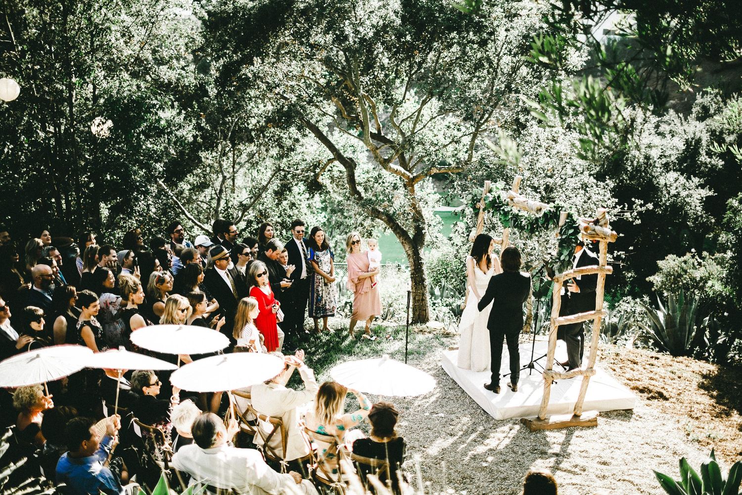 bride and groom standing at altar with friends and family watching
