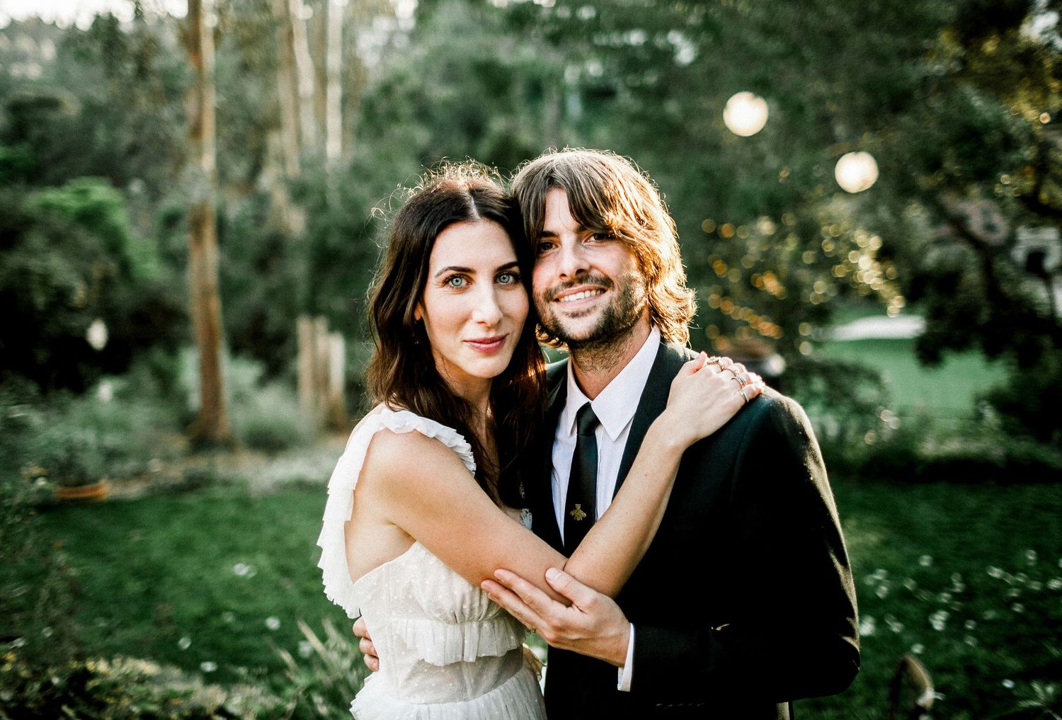 bride and groom looking at camera while holding each other