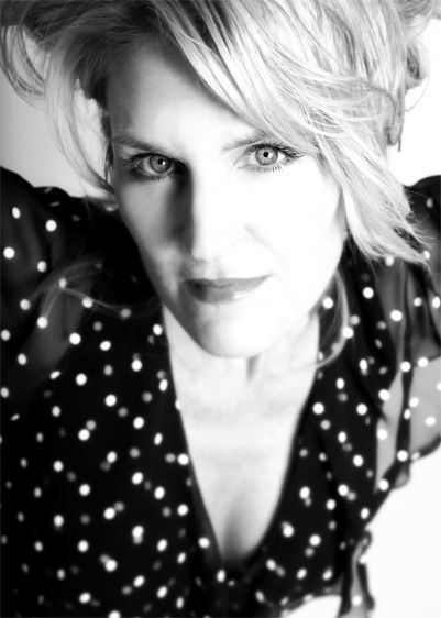 Black and white portrait wearing polka dot dress with dramatic lighting.