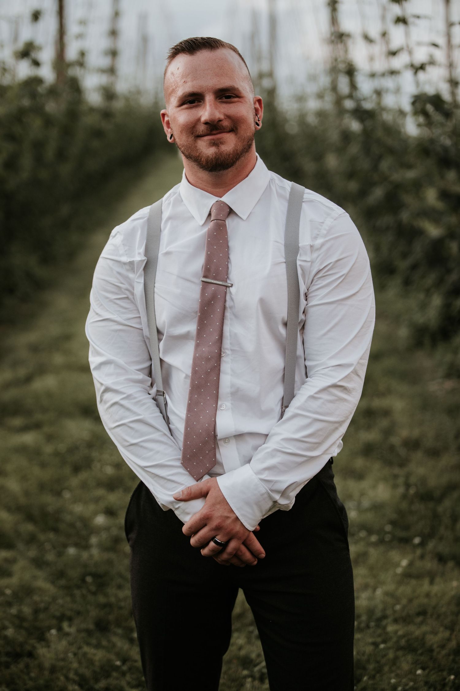 groom posing at climbing bines