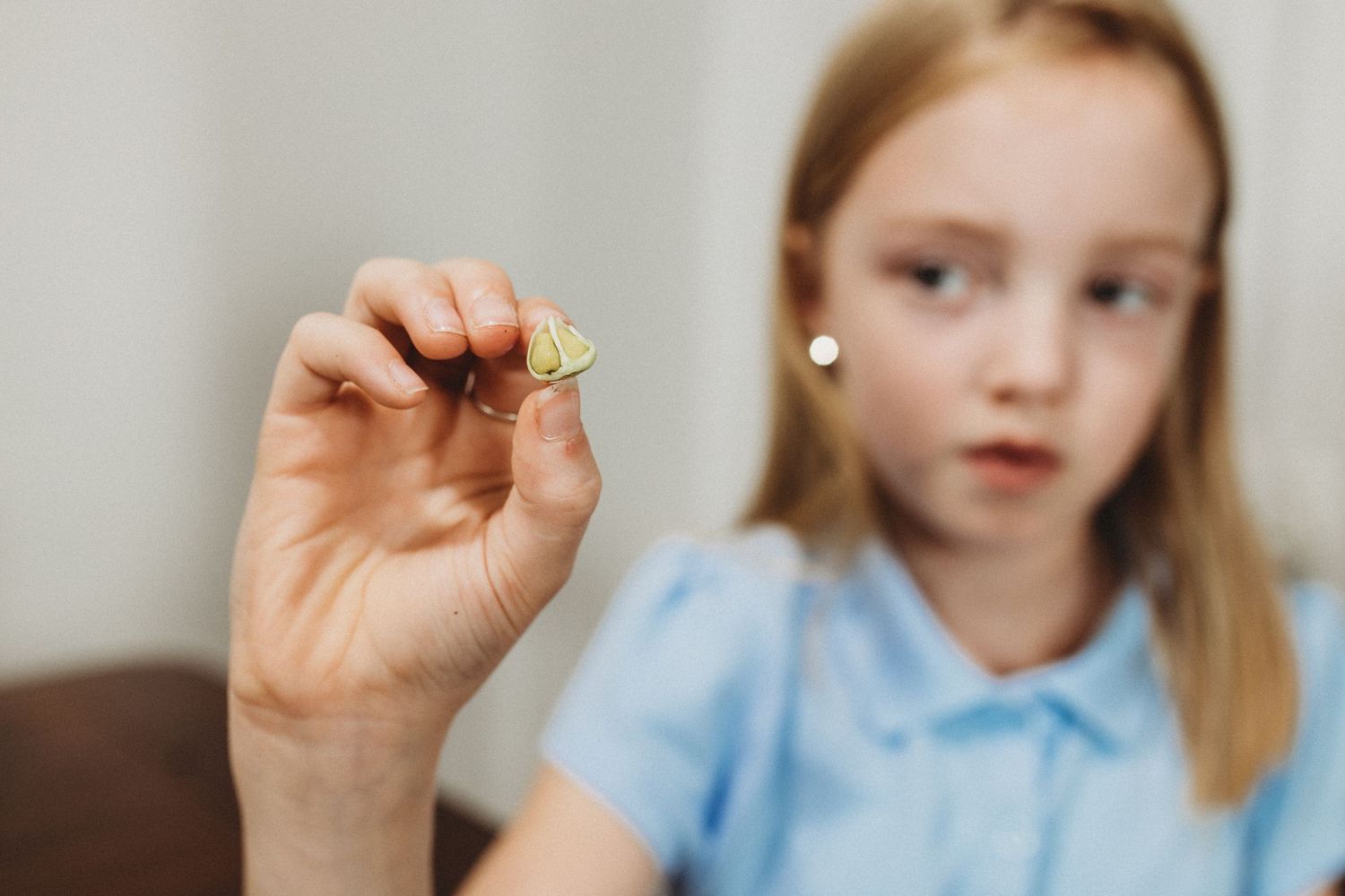 Blonde girl showing calla lily seeds